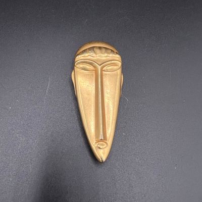 une image représentant un objet métallique doré posé sur une surface noire