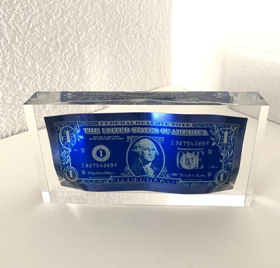 a close up of a blue and white paper money in a clear box