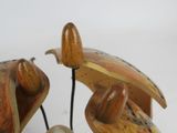 a wooden sculpture of a bird with a pearl in it ' s beak