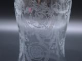 a glass vase with a design on it sitting on a table
