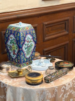 un vase bleu et blanc posé sur une table où se trouvent d'autres objets