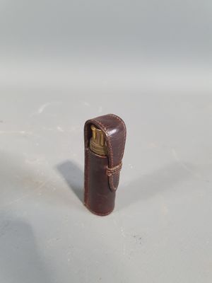 a small leather case with a lighter inside of it