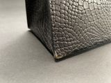 a black purse that is sitting on a table