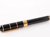 un gros plan d'un stylo-plume posé sur une surface blanche