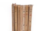 several old books are stacked on top of each other on a white surface