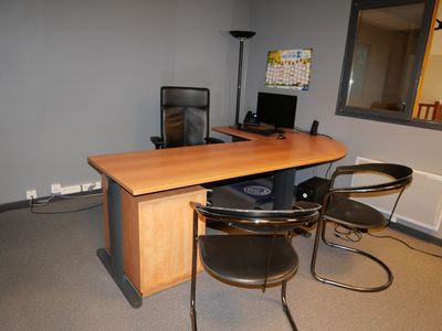 un bureau avec deux chaises et un ordinateur dessus