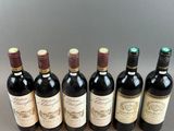 six bottles of wine lined up in a row on a table