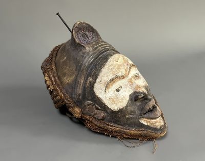 un gros plan d'un masque posé sur une surface grise