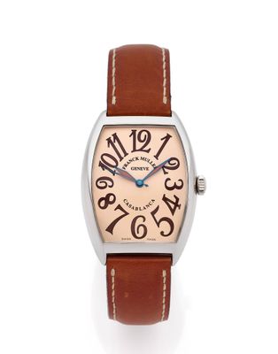 gros plan d'une montre sur une surface blanche avec un bracelet marron