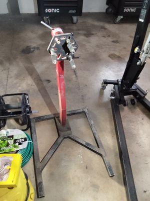 quelqu'un travaille sur une machine dans un garage, entouré d'autres outils