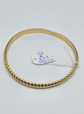 Gros plan sur un bracelet en or portant une étiquette