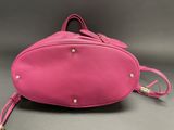 a pink purse sitting on top of a gray surface