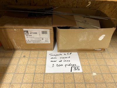 un panneau posé par terre devant une pile de cartons