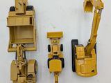three toy construction vehicles that are next to each other