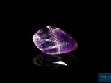 a purple amethorate stone on a black surface