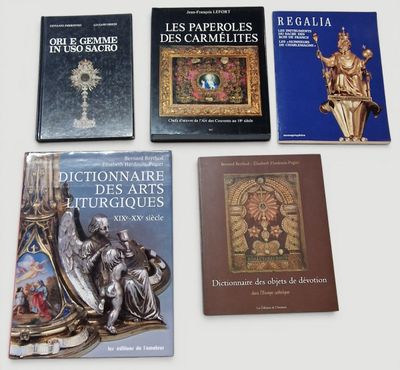 plusieurs livres posés sur une table, à côté d'une statue de Jésus et d'autres objets religieux