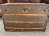 an old trunk sitting on the floor in front of a dresser