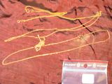 une photo d'un collier en or posé sur un tissu rouge