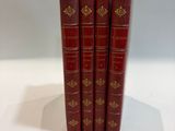 three red books sitting on top of each other on a white surface