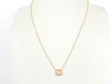 un collier en or orné d'un pendentif en forme d'initiale sertie d'un diamant, autour du cou d'un mannequin