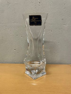 un vase en verre avec une étiquette dessus, posé sur une table