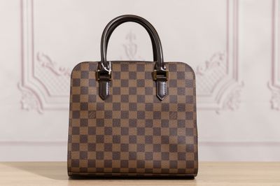 un sac à main marron et noir posé sur une table en bois