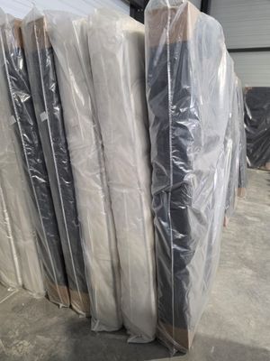 une pile de matelas emballés dans du plastique dans un entrepôt