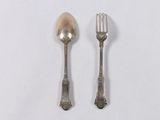 two spoons and a fork on a white surface