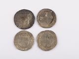 three silver and bronze coins on a white surface with a white background