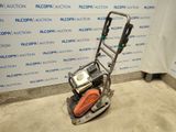 a close up of a small machine on the ground in front of a wall
