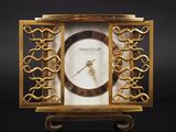 an image of a gold clock with a white face on a black background