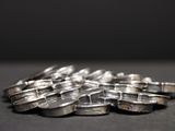 a pile of silver rings sitting on a table