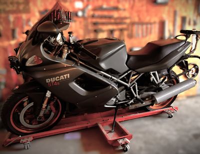 une moto posée sur un pont élévateur dans un garage