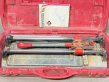 une mallette rouge contenant des outils, posée sur une table