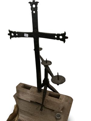 statue d'un homme tenant une croix, posée sur un socle en bois