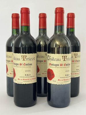 quatre bouteilles de vin rouge sont alignées sur une surface blanche