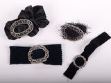 three pieces of black and silver jewelry on a white surface