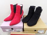 pair of red and black sued ankle boots sitting on top of boxes