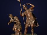bronze statue of a man holding a spear and a woman kneeling on a green marble base