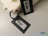 a white pillow with a tag on it next to a pillow