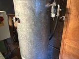 a water heater in the corner of a room next to a refrigerator