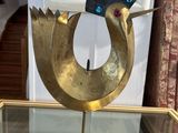 a gold bird statue on a glass table in a room