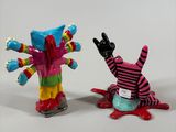 two figurines of a clown and a clown on a skateboard