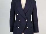 un blazer bleu marine à boutons dorés sur un mannequin