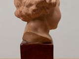 sculpture of a woman ' s head on a wooden stand