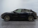 the black porsche cayen is parked in a large room