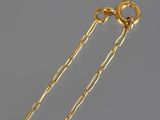 a close up of a pair of gold chain earrings on a gray surface