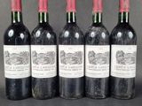 four bottles of wine are lined up on a table