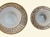 two white and gold plates with gold designs on them