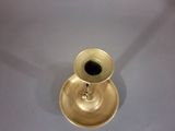 a gold candle holder with a black candle in it